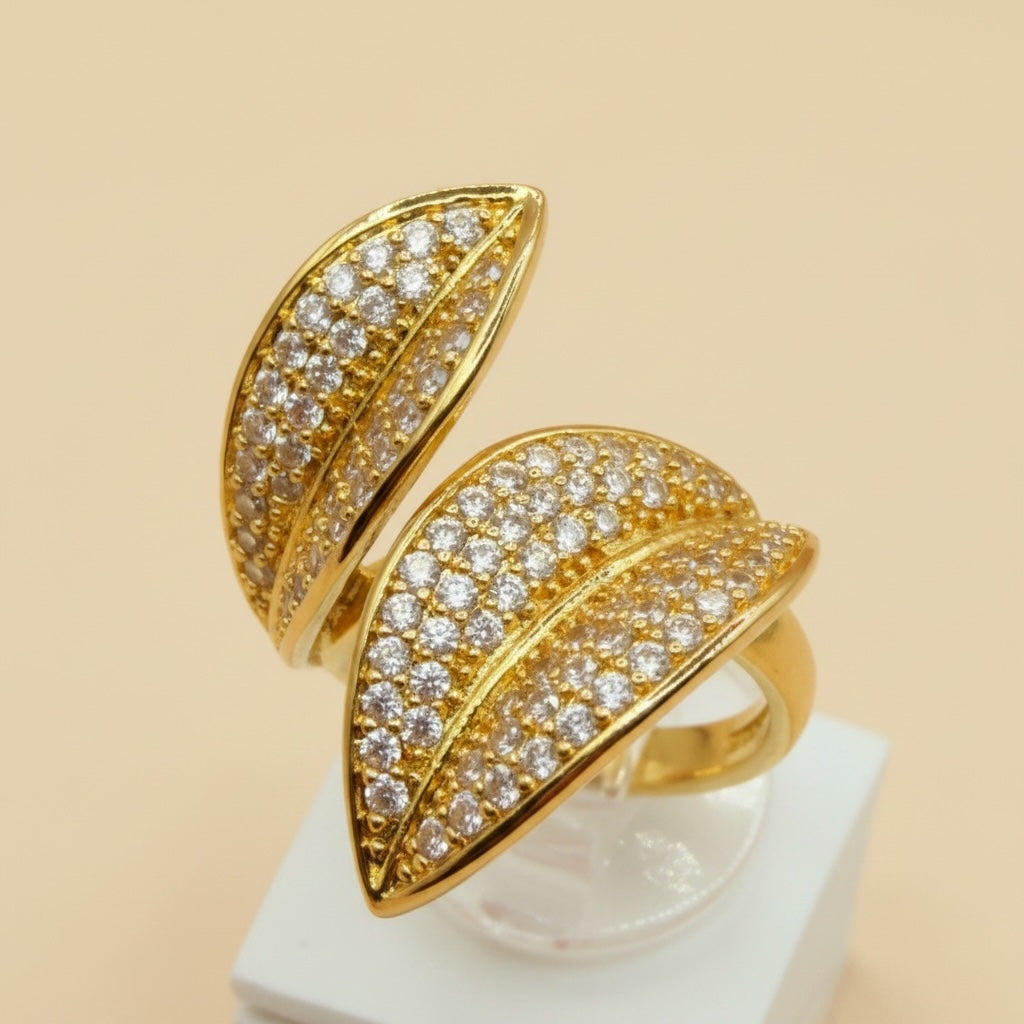 Riri Bespoke Jewelry gold-tone bypass statement ring featuring two leaf motifs encrusted with sparkling cubic zirconia