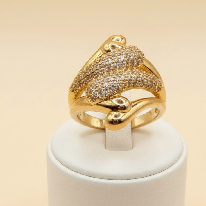 Riri Bespoke Jewelry gold-tone statement ring with a sculptural fluid design and shimmering pavé-set stones.