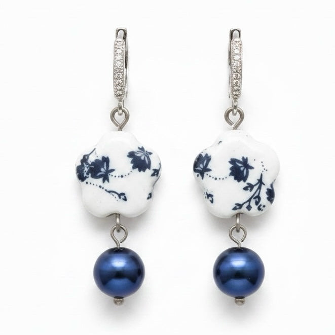 Riri Bespoke Jewelry floral porcelain drop earrings with blue and white ceramic charms, blue pearls, and crystal hoops.
