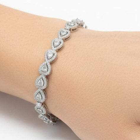 Riri Bespoke Jewelry silver-tone tennis bracelet with pear-shaped teardrop links and shimmering pavé stones on a wrist