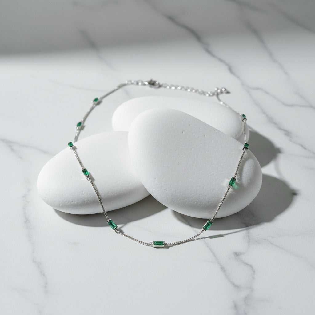 Riri Bespoke Jewelry emerald baguette station necklace on white stones with a silver-tone chain