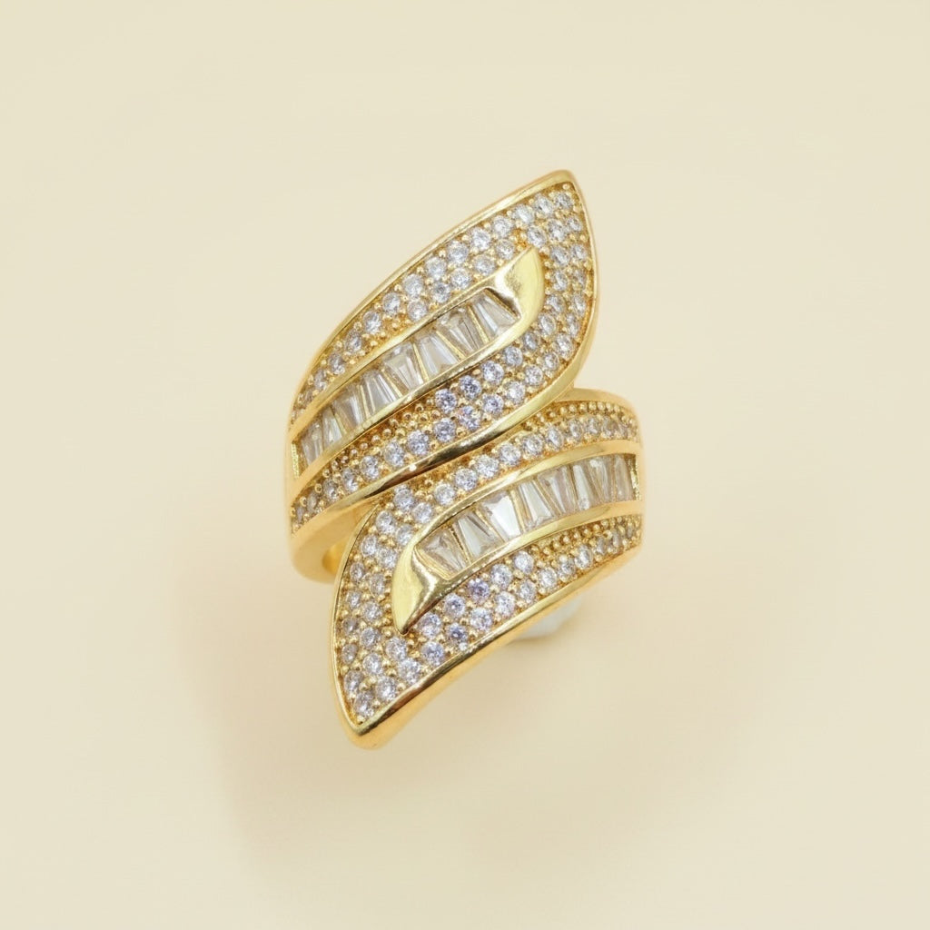 Riri Bespoke Jewelry gold-tone bypass statement ring featuring pave-set round crystals and baguette-cut stones.