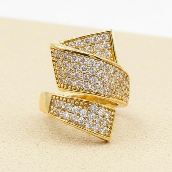 Riri Bespoke Jewelry gold-tone geometric statement ring with cubic zirconia stones in an open wrap-around design.