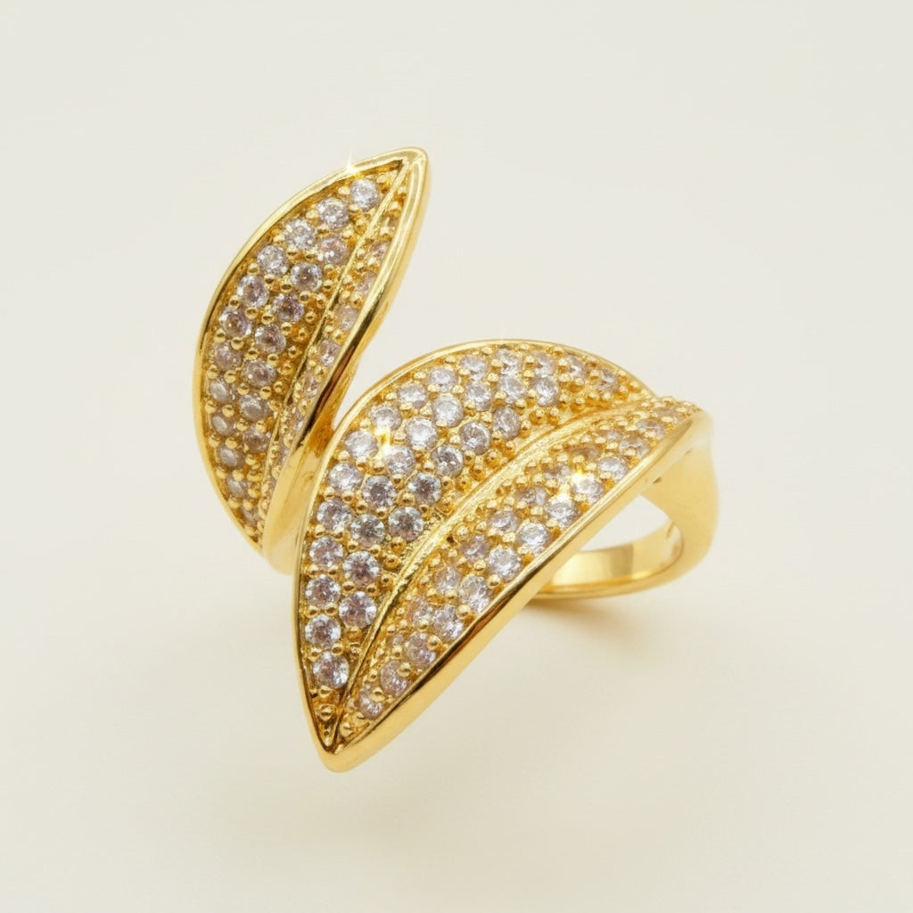 Riri Bespoke Jewelry gold-tone bypass statement ring featuring two leaf motifs encrusted with cubic zirconia stones.