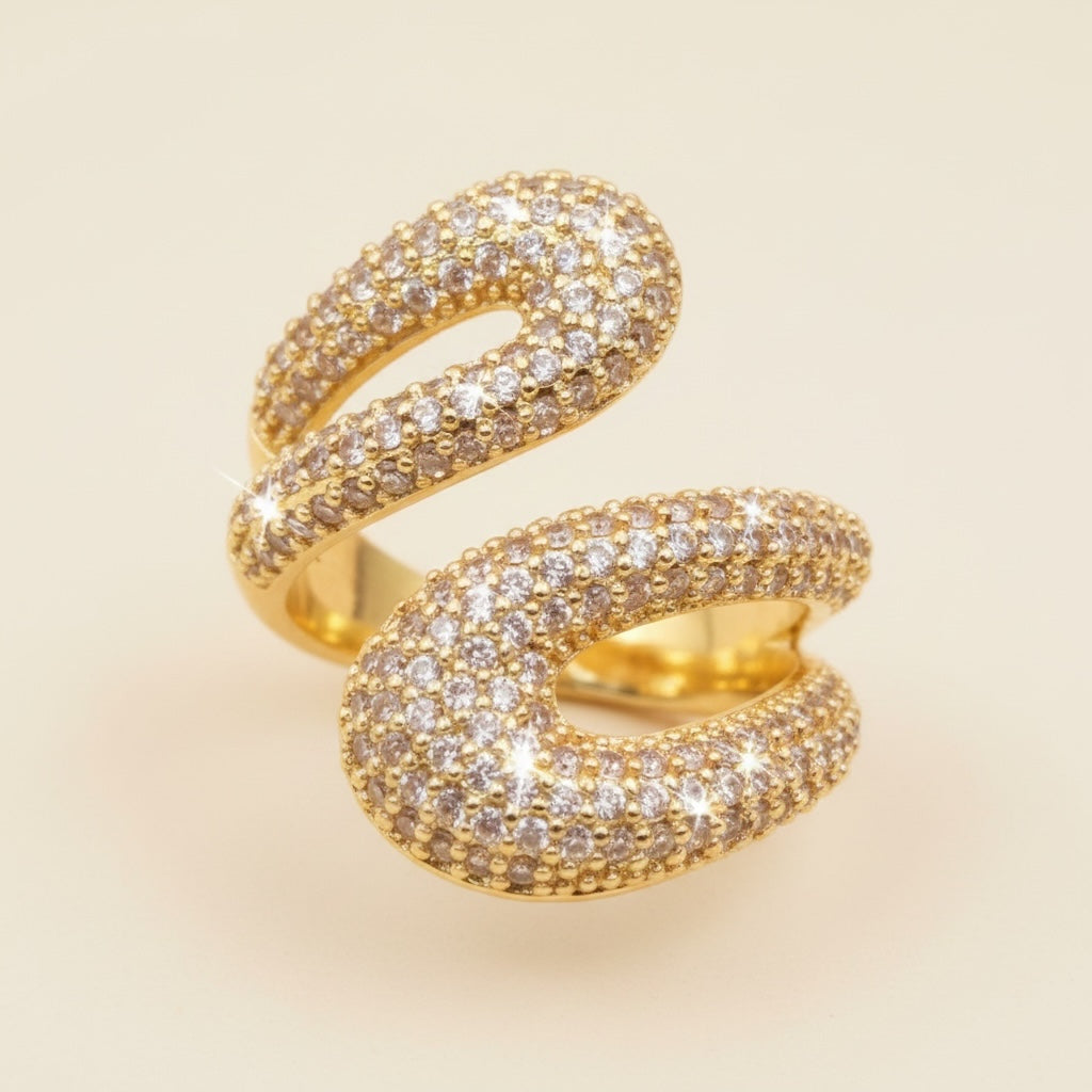 Riri Bespoke Jewelry gold-tone spiral statement ring with pavé-set crystals in an open-ended bypass design.