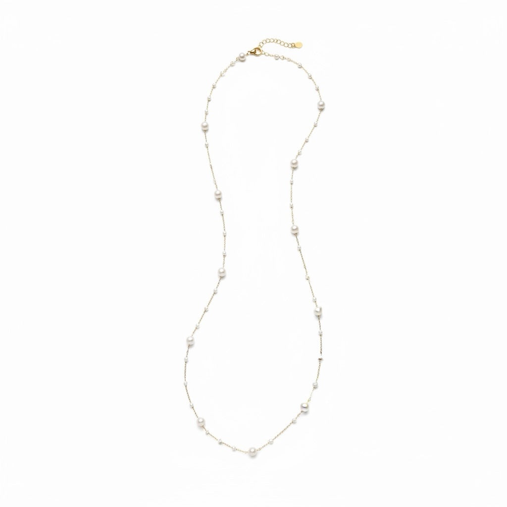Riri Bespoke Jewelry long station necklace featuring lustrous white pearls spaced on a delicate gold-tone chain.