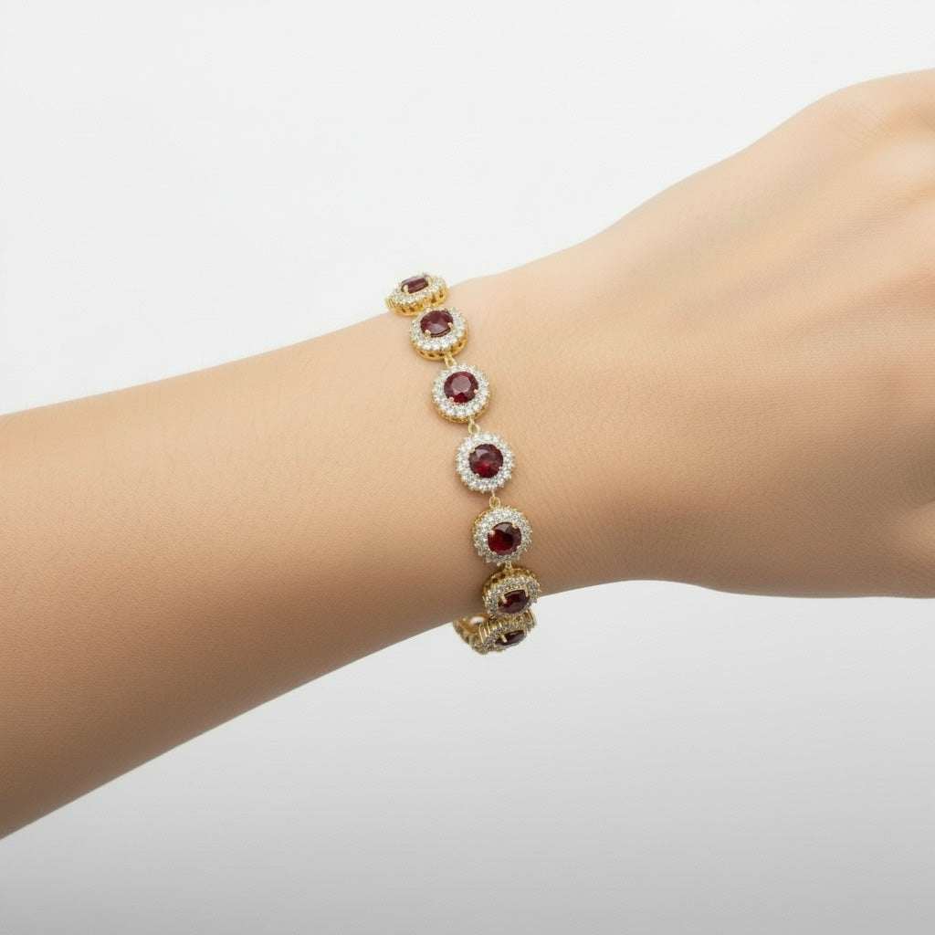 Riri Bespoke Jewelry gold-tone link bracelet featuring round red stones surrounded by clear crystal halos on a wrist